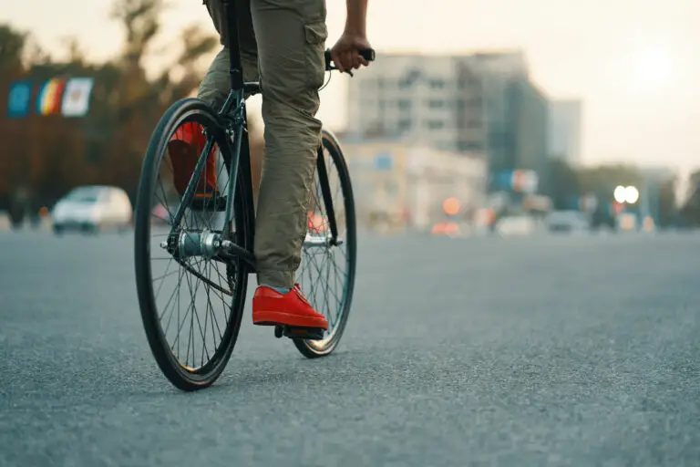 Closeup of casual man legs riding classic bike on city gray road