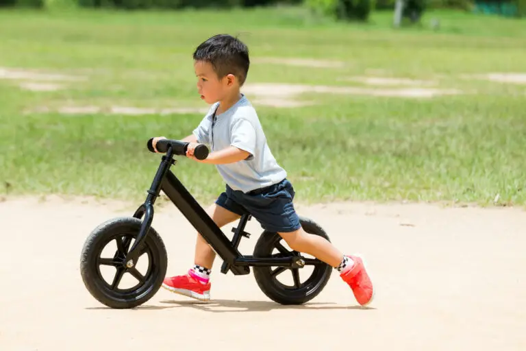 Little boy playing with balance bicycle